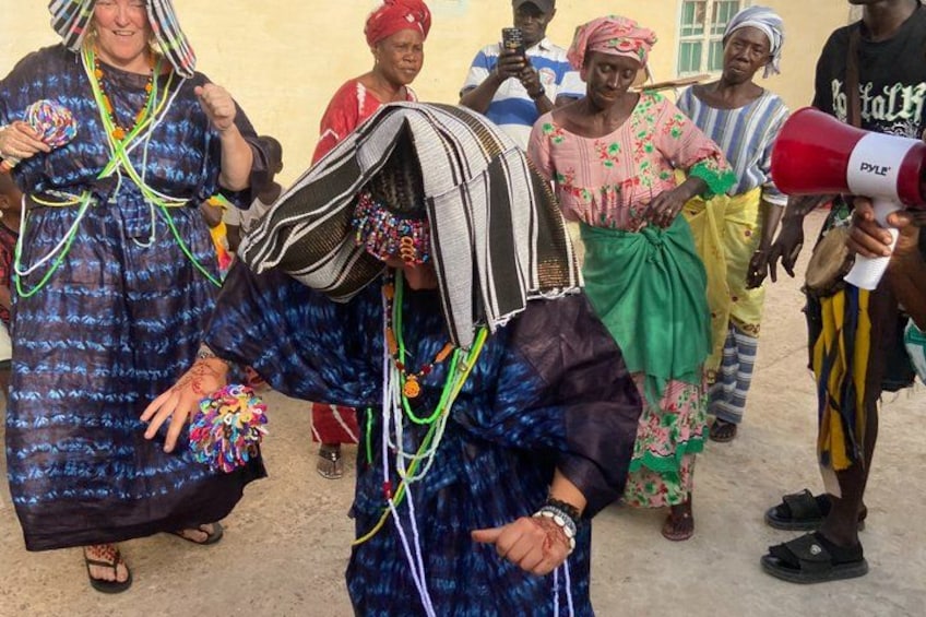 People in traditional attire, some with head coverings, and one person holding a megaphone. 1