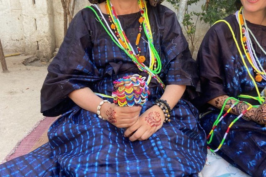 Two individuals wearing traditional attire with intricate beadwork and henna designs. 4