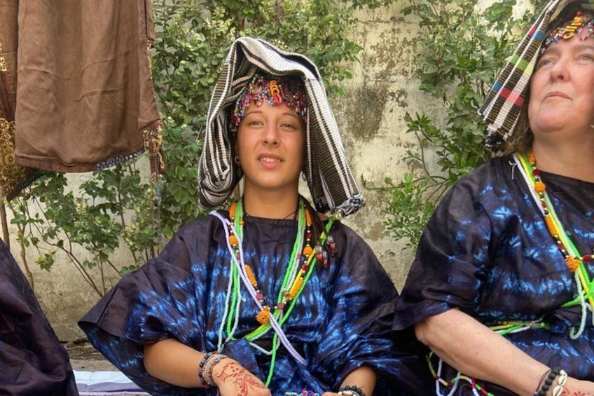 Two individuals wearing traditional attire with head coverings and colorful accessories. 3