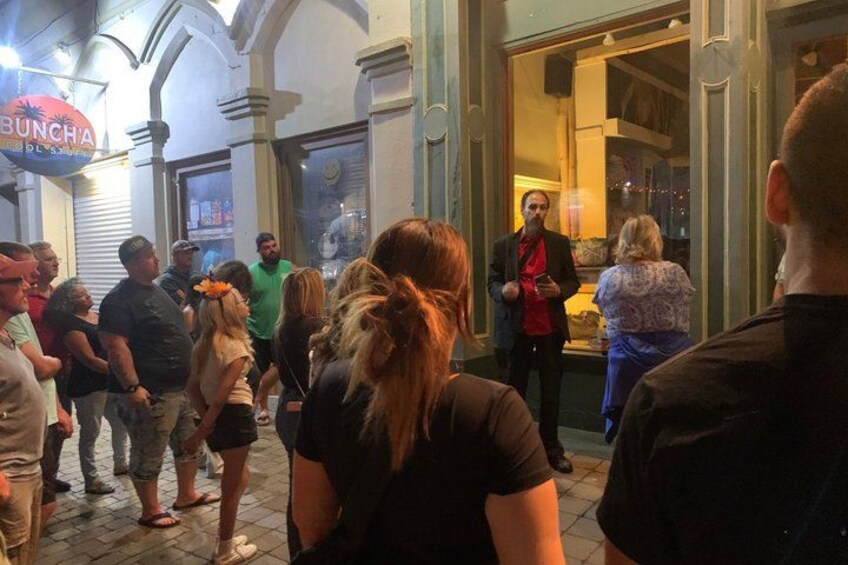 A crowd of people outside a building with a sign that reads 'BUNCHA.' 2