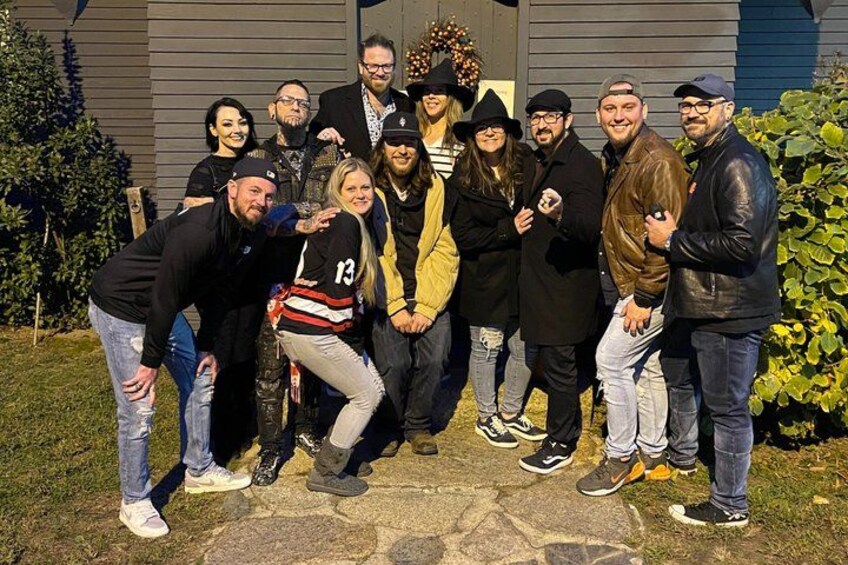 A group of people posing in front of a house with a wreath on the door. 5