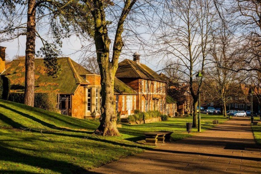 A residential area with houses, a grassy lawn, a pathway, and trees. 2
