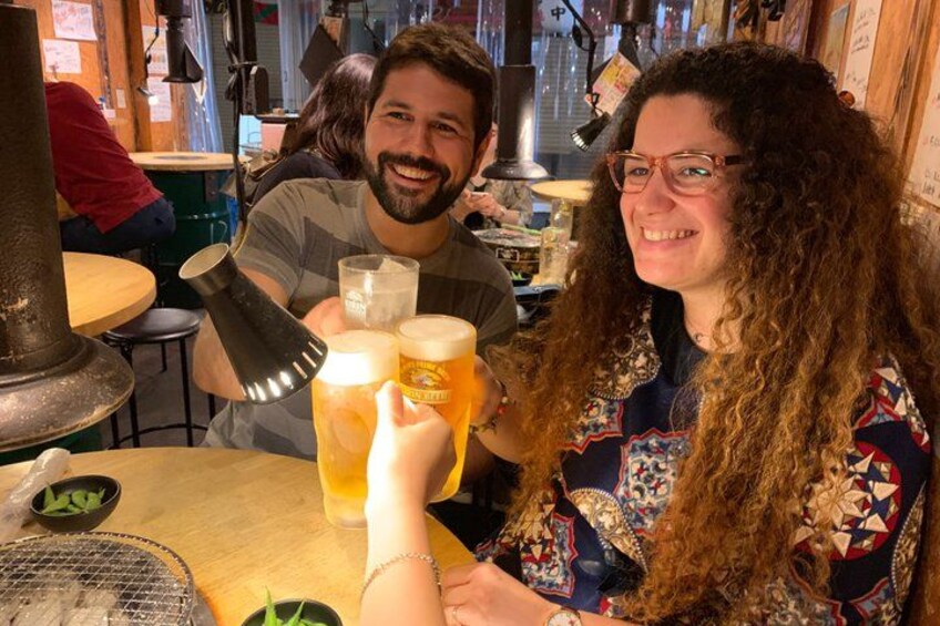 Two people at a bar with glasses of beer. 4