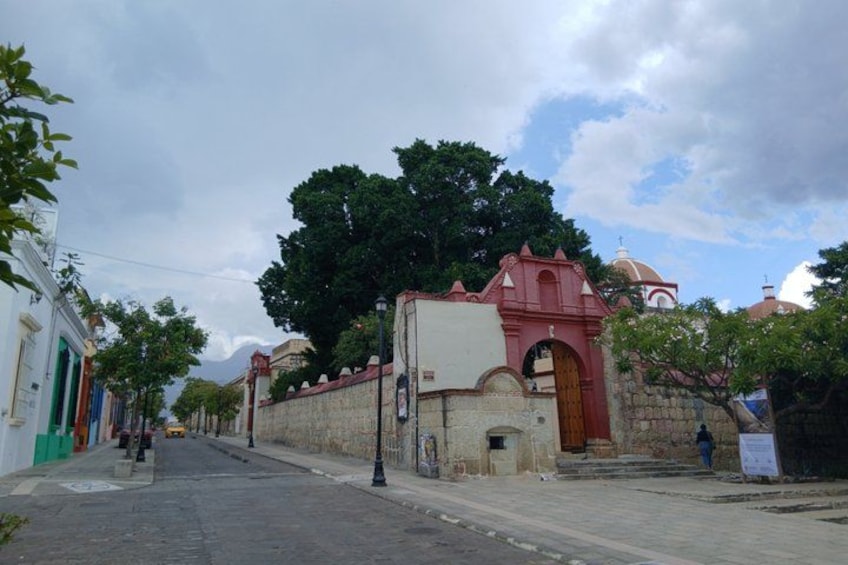 A street with a red church, a white building, and a stone wall. 4