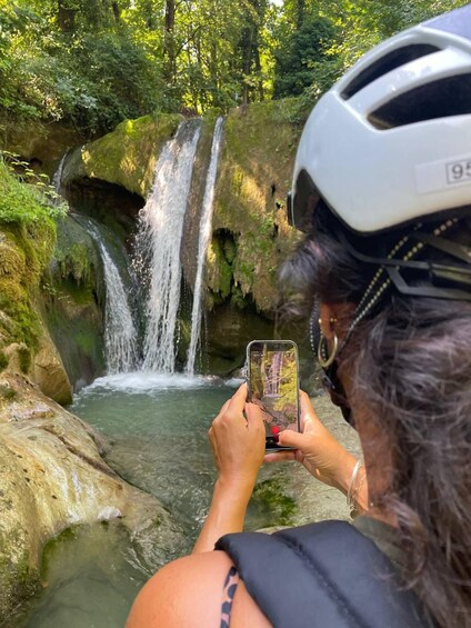 A person taking a photo of a waterfall with a smartphone. 1
