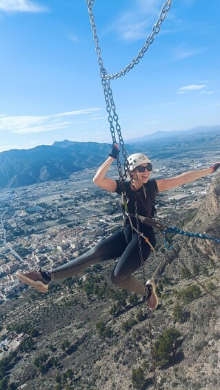 A person on a zip line with a cityscape in the background. 2