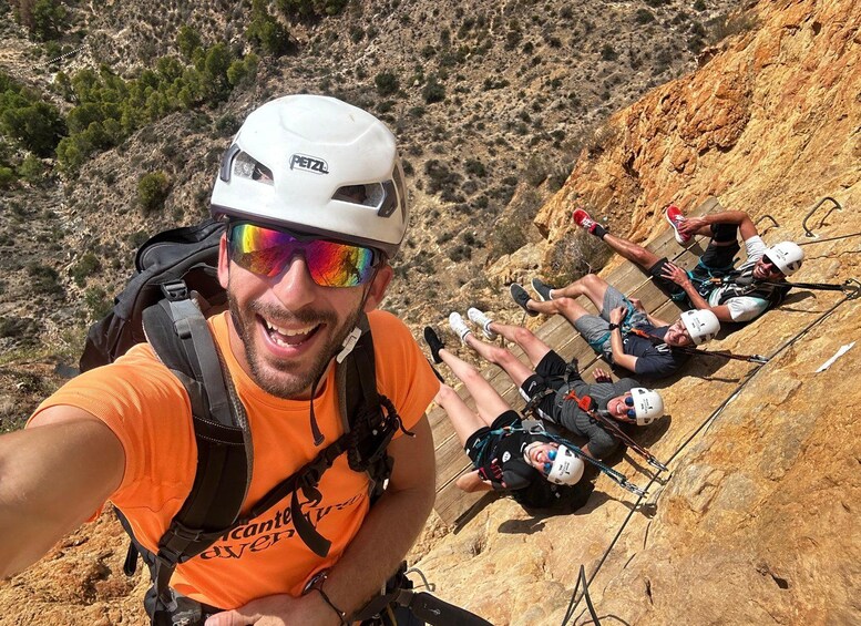 A group of people rappelling down a rocky cliff. 1
