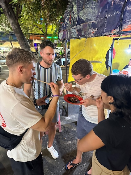 Personas comiendo comida callejera en un mercado al aire libre. 2