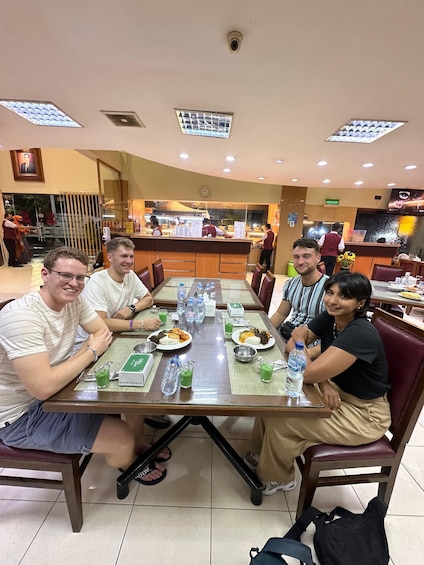 Un grupo de personas cenando en un restaurante con mostrador y carta. 3