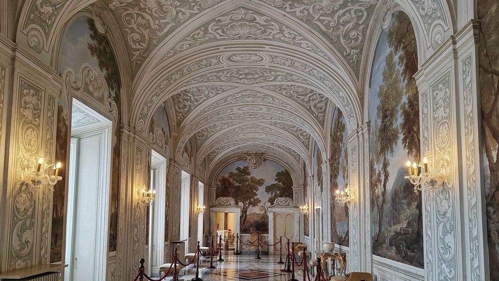 An ornate hallway with high ceilings and intricate wall decorations. 5