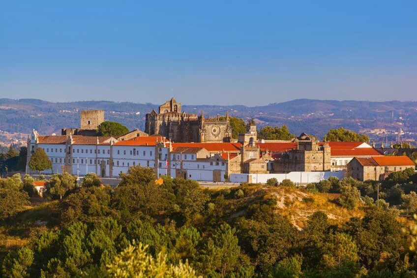 A historic town with a prominent church and castle, surrounded by greenery and hills. 1
