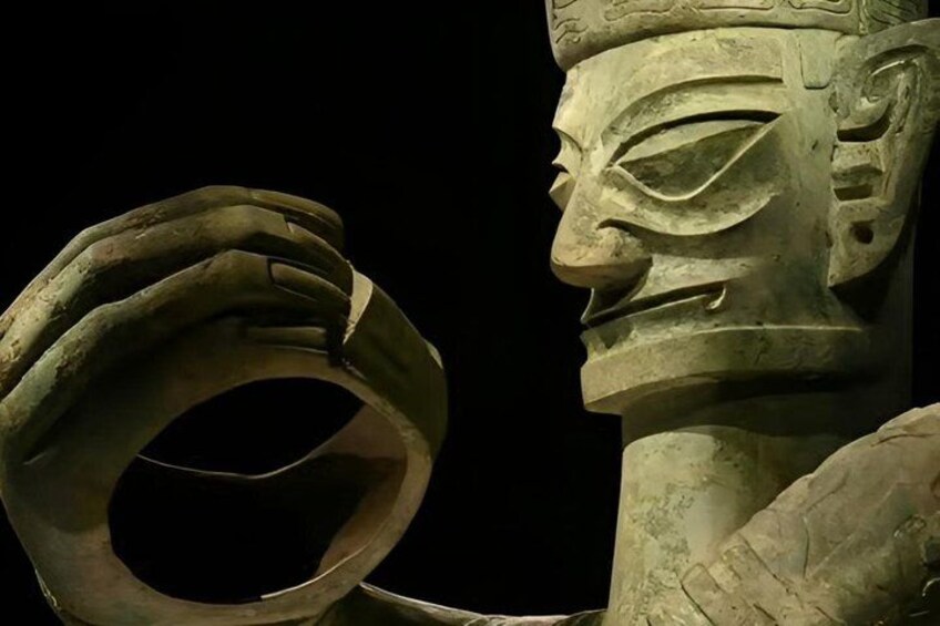A stone sculpture with a hand holding a circular object. 5