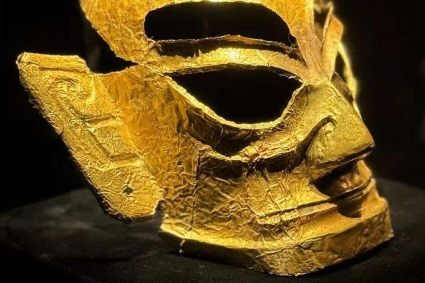 A golden mask with intricate details and a dark background. 4