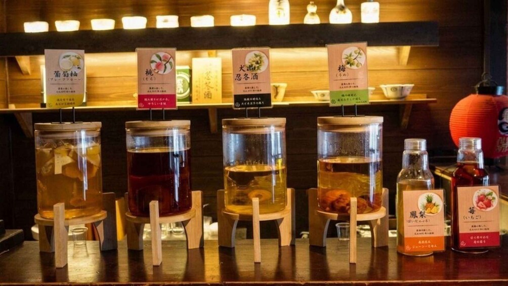 A selection of beverages in glass jars with wooden stands, each labeled with Japanese text. 5