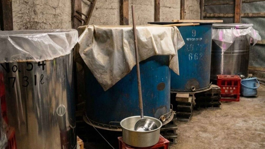Large industrial tanks, some covered with cloth, in a storage or workshop area. 4