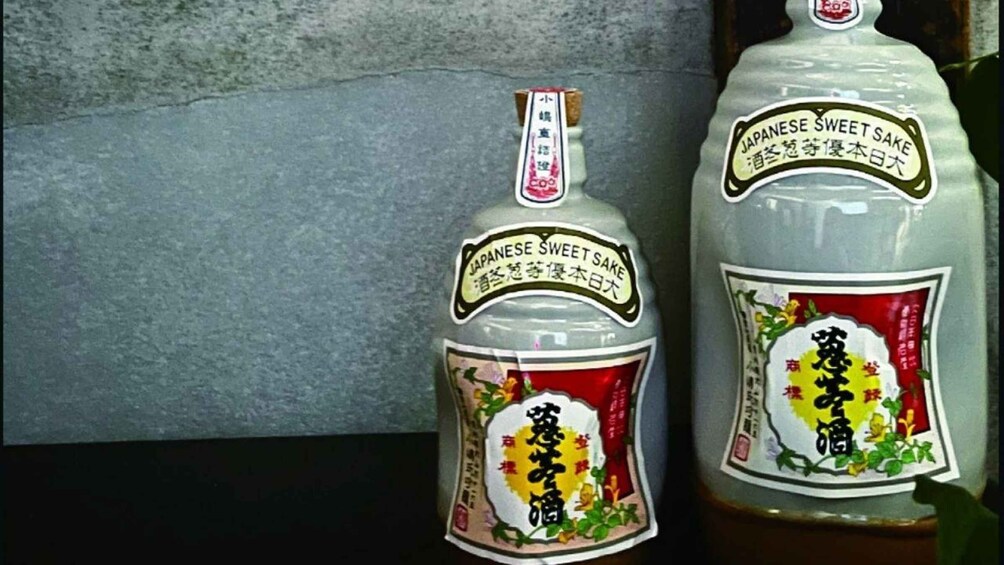 Two bottles of Japanese sweet sake with labels and a cork. 1