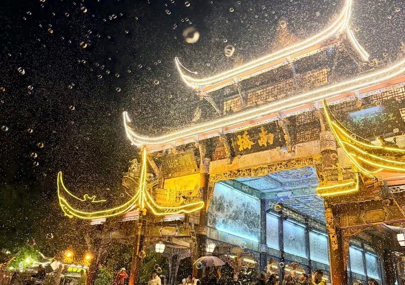 A traditional Chinese building with illuminated decorations and a large, ornate gate. 1