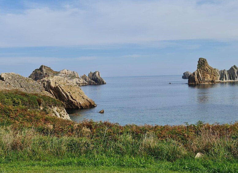 A coastal landscape with rocky formations and calm sea. 5