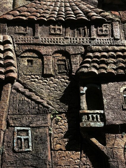 Un edificio in pietra con elaborate sculture, un tetto in tegole e una piccola finestra. 2