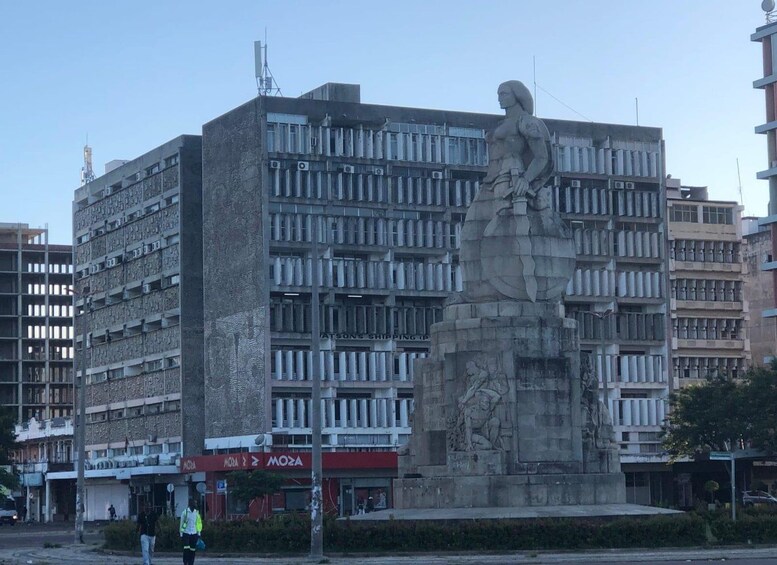 A large building with a statue in front. 2