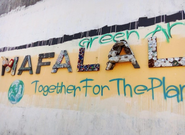 A wall with the word 'MAFALAL' painted in colorful letters, with 'green' written above it. 1