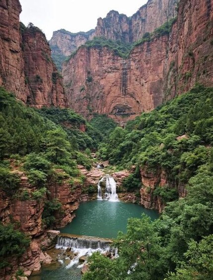 Un canyon avec une cascade et une étendue d'eau à son pied. 4