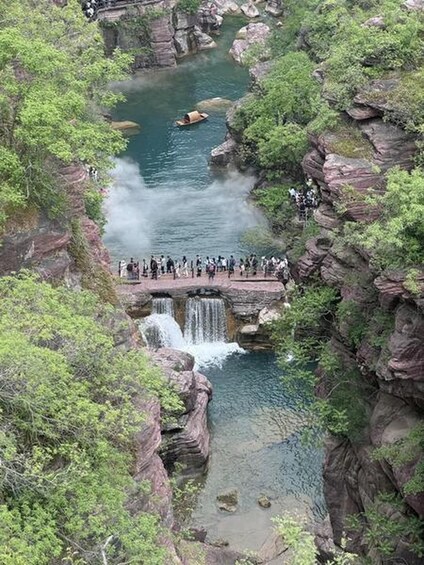 Une cascade se jetant dans une rivière, le tout entouré de falaises rocheuses et d’une végétation luxuriante. 3