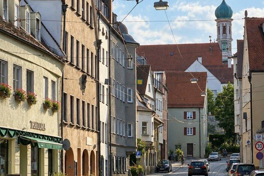 A street with buildings, cars, and a clock tower. 3