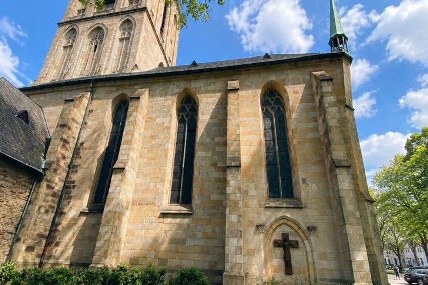 A church with a tall tower, arched windows, and a cross. 5