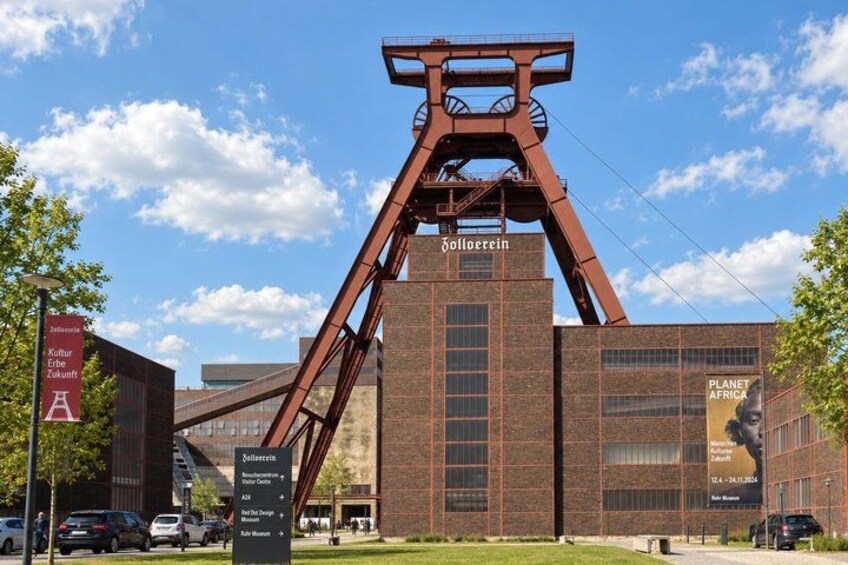 A large metal structure with the word 'Solothurn' on it, surrounded by modern buildings and a clear sky. 4