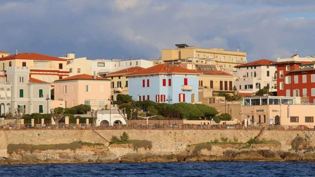 A coastal town with colorful buildings, a stone wall, and the sea. 5