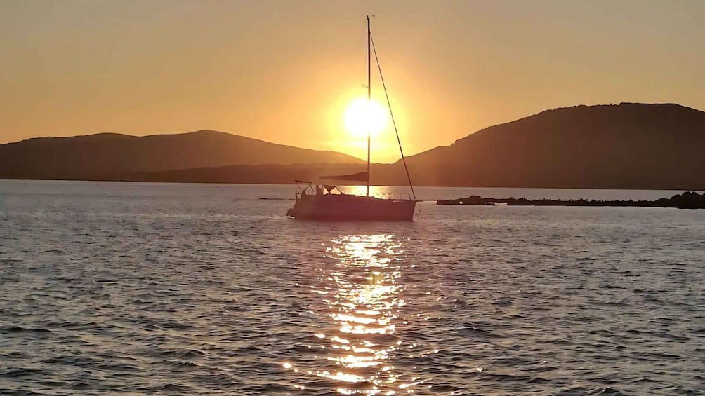 A sailboat on calm water with a sunset in the background. 1