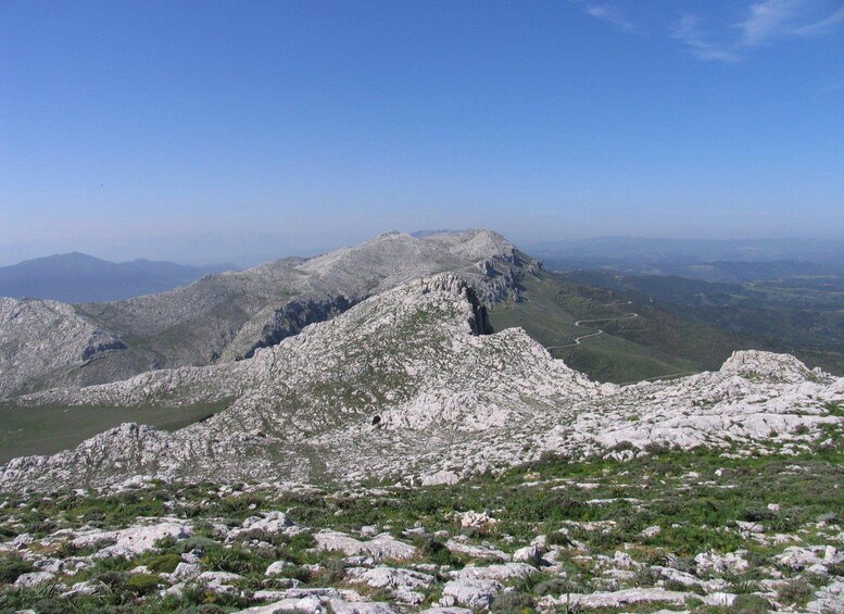 A rugged mountain landscape with rocky terrain and sparse vegetation. 5