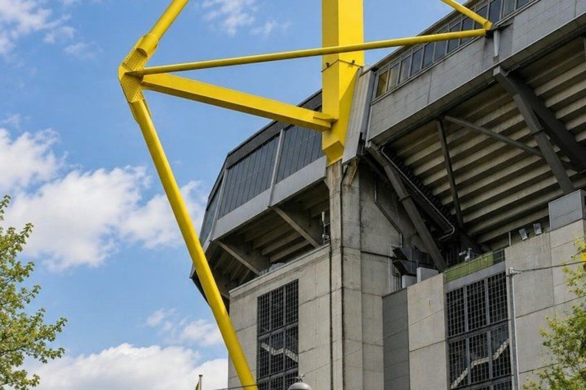 A yellow crane structure, a building with large windows, and a clear blue sky. 2