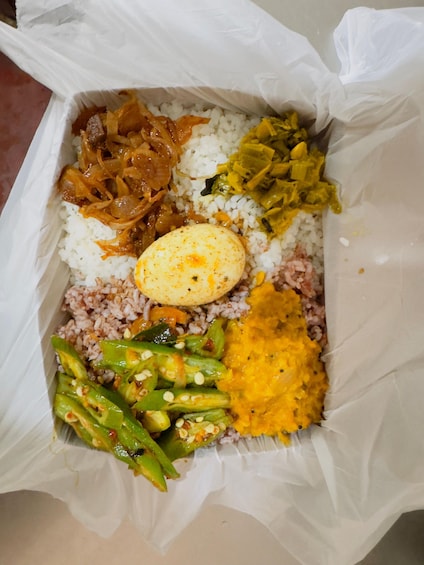A meal consisting of rice, a boiled egg, green vegetables, and a yellow curry. 1