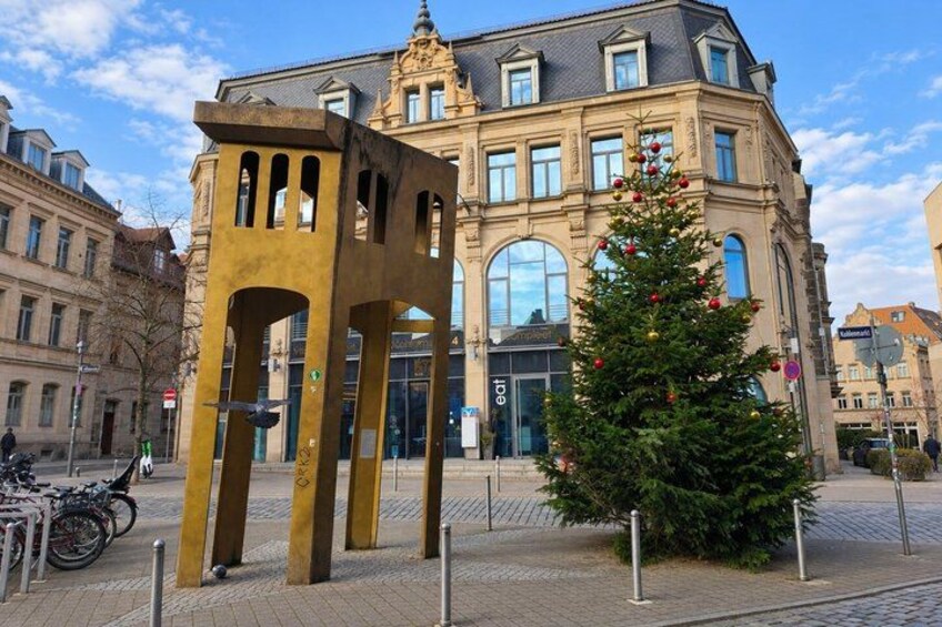 A Christmas tree, a yellow sculpture, and a historic building. 4