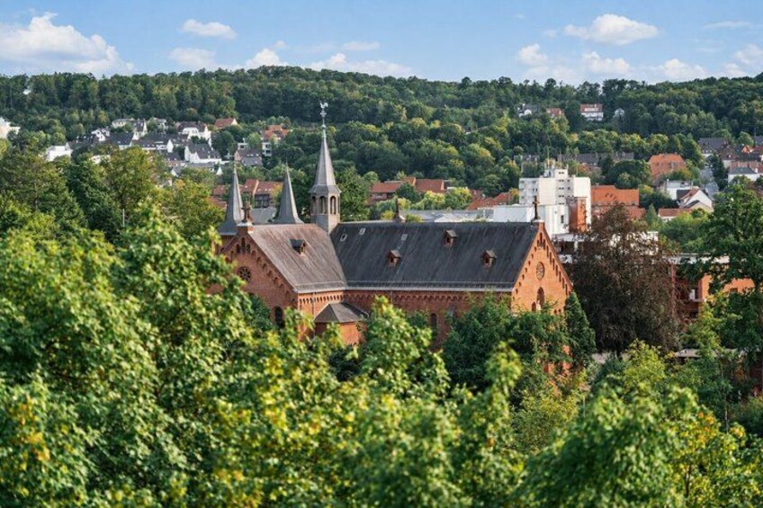 A church with a steeple, surrounded by greenery and a town in the background. 3