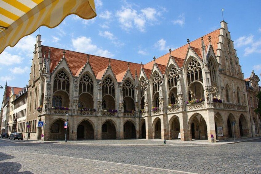 A historic building with Gothic architecture, featuring pointed arches and a red-tiled roof. 3