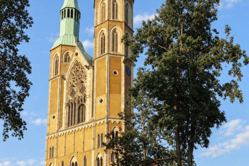 A church with a clock tower and a green spire. 4