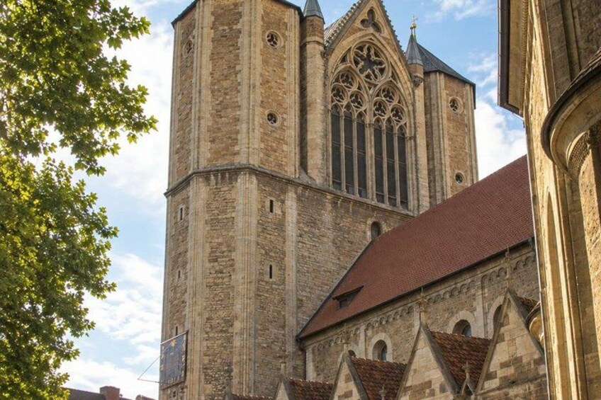 A historic church with a tall bell tower and a large rose window. 5