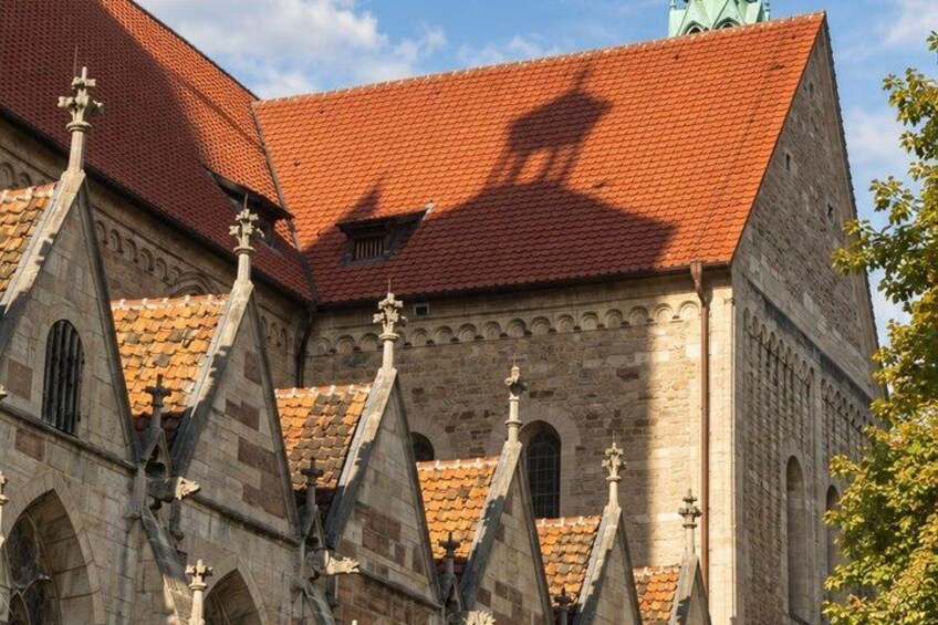 A historic building with a red-tiled roof and pointed architectural features. 3