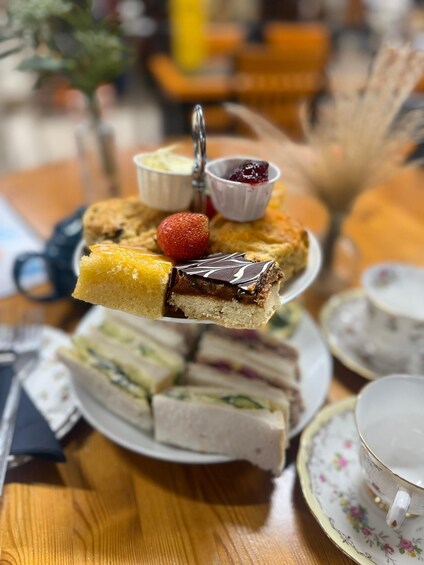 A tiered dessert stand with various pastries and a strawberry. 2