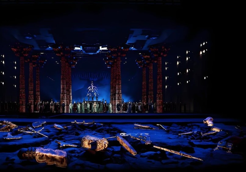 A stage with columns, a large sculpture, and scattered objects. 2
