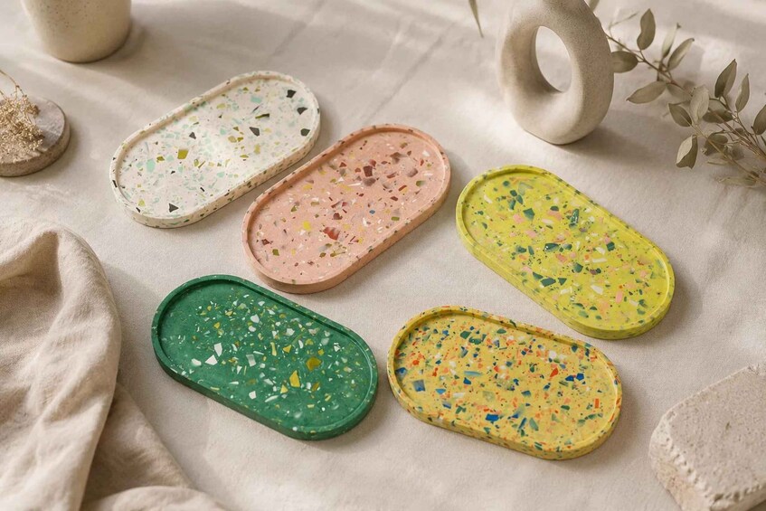 Five petri dishes with colorful specks on a fabric surface. 2