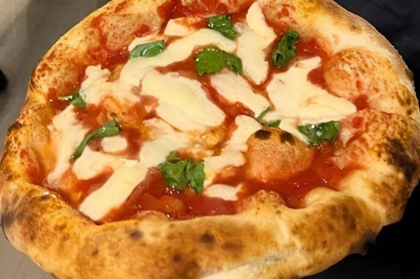A pizza with tomato sauce, cheese, and basil. 2