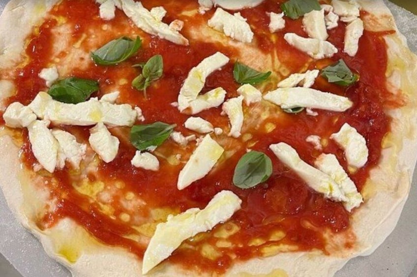 A pizza with tomato sauce, cheese, and basil leaves. 5