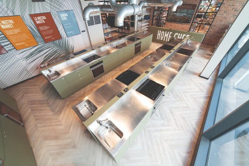 A modern kitchen with stainless steel appliances, wooden flooring, and a herringbone pattern backsplash. 4