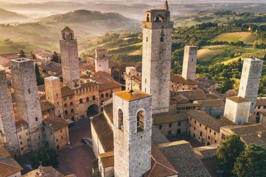 A medieval town with prominent stone towers and a central square. 4