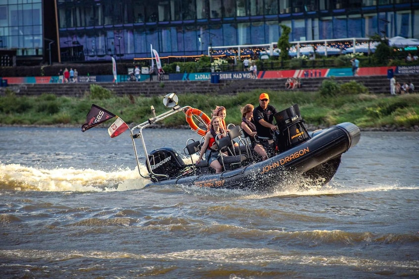 A speedboat with the name 'JOHN DRAGON' on its side, moving swiftly through the water, creating a large wake behind it. 1