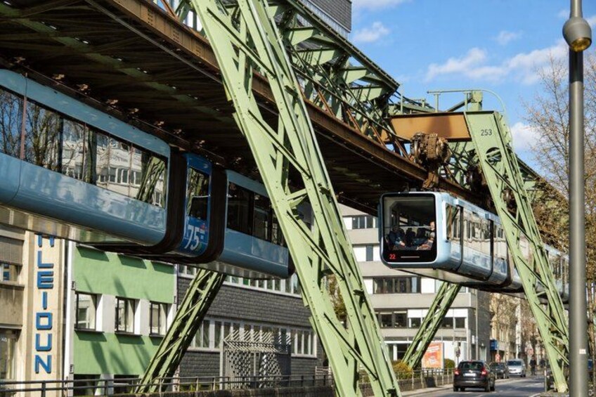 A cable car system with a green metal structure, a blue cable car, and a sign with the number 253. 2